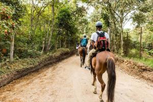 twee mensen die paardrijden over een onverharde weg bij San Augustin - Superior Double Room - Colombia in San Agustín