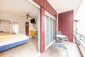ルガノにあるHotel Atlantico self check-inのベッドルーム1室(ベッド1台、テーブル、椅子付)