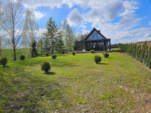 KrasnopolにあるDomek nad jezioremの緑の野原の真ん中にある家