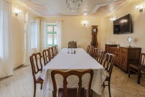 Pastorówka في شفيدنيتسا: غرفة طعام مع طاولة وكراسي وساعة