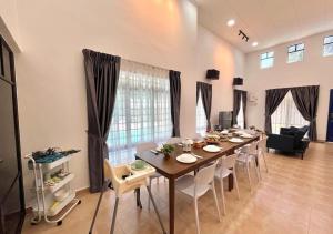 a dining room with a long table and chairs at A'famosa Bungalow Villa 859 in Kampong Alor Gajah