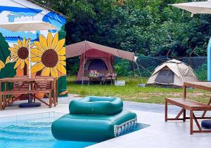 a pool with a tent and a table and chairs and a tentbecue at A'famosa Bungalow Villa 859 in Kampong Alor Gajah