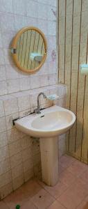 een badkamer met een wastafel en een spiegel aan de muur bij Kafka Gardens in Kisumu