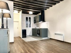 uma cozinha com paredes brancas e um tecto preto em Studio avec wifi a Saint Germain en Laye em Saint-Germain-en-Laye