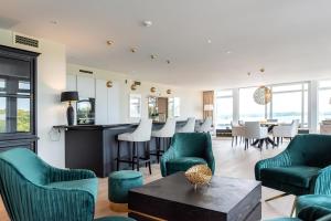 een woonkamer met groene stoelen en een tafel bij Intermar Hotel & Apartments in Glücksburg