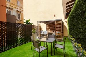 a patio with a table and chairs on the grass at Ripetta Luxury Apartments in Rome