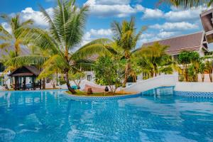 a pool at a resort with palm trees at Manyo Hotel and Resort in Luang Prabang