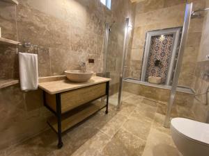 a bathroom with a sink and a toilet and a shower at Cappadocia Fairy Tale Suites in Goreme