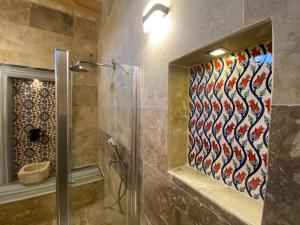 baño con ducha y puerta de cristal en Cappadocia Fairy Tale Suites en Göreme