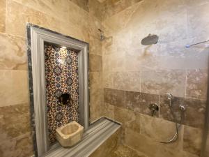 a bathroom with a shower with a mirror at Cappadocia Fairy Tale Suites in Goreme
