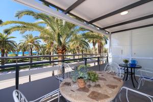 a balcony with a table and chairs and palm trees at UHC RODAS APARTMENTS in Salou