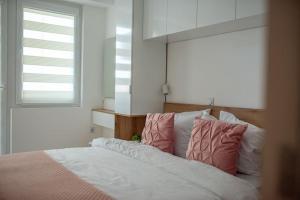 ビトラにあるJoy apartmentのベッドルーム1室(ピンクと白の枕が備わるベッド1台付)