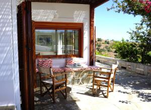a patio with a table and chairs and a mirror at Villa Tsonima in Agia Marina Mikrolimanou