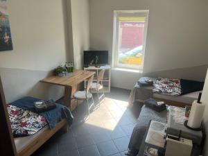 ein Zimmer mit einem Schreibtisch und einem Sofa in der Unterkunft Šiauliu apartamentai in Šiauliai
