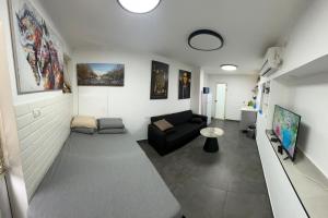 - un salon avec un canapé et une télévision dans l'établissement נופש בעמק, à Beït Shéan