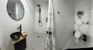 La salle de bains blanche est pourvue d'une douche et de toilettes. dans l'établissement נופש בעמק, à Beït Shéan