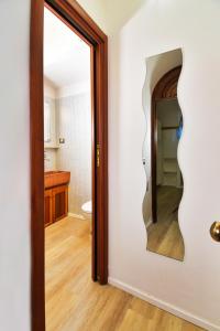 La salle de bains est pourvue d'un miroir et de toilettes. dans l'établissement Perugia-Apartments Via Favorita, à Pérouse