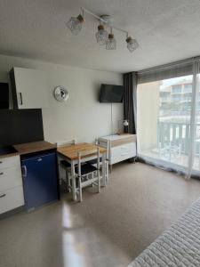 Schlafzimmer mit einem Schreibtisch, einem Tisch und einem Bett in der Unterkunft Studio Gruissan in Gruissan