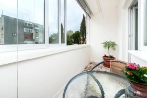 a balcony with a glass table and a window at Apartman Oly in Rovinj