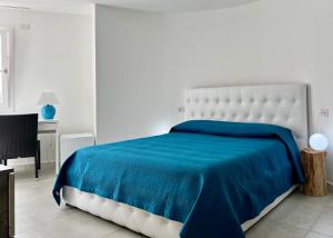 a bedroom with a bed with a blue blanket at Sole Matto Rooms in Olbia