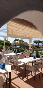a group of tables and chairs with a large umbrella at El Capistrano Sur in Nerja