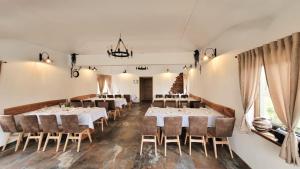 una sala da pranzo con tavoli e sedie bianchi di Kuća za odmor Duga Pet friendly imanje 13500 m2 