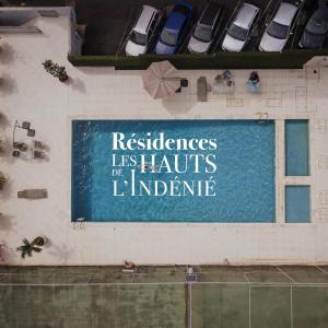 a sign on the side of a building with parked cars at Résidences Les Hauts de l'Indenié in Abidjan