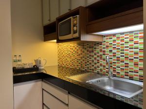 a kitchen with a sink and a microwave at Silom Forest Exclusive Residence in Bangkok