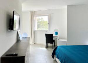 a bedroom with a bed and a desk and a window at Sole Matto Rooms in Olbia