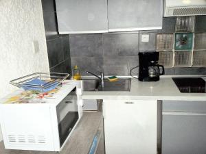 eine weiße Küche mit einer Spüle und einer Theke in der Unterkunft Studio a Saint Mandrier sur Mer a 700 m de la plage avec terrasse in Saint-Mandrier-sur-Mer