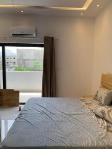 a bedroom with a bed and a large window at Cœur tranquille in Cotonou