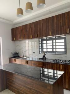 cocina con armarios de madera y encimera en Cœur tranquille en Cotonú
