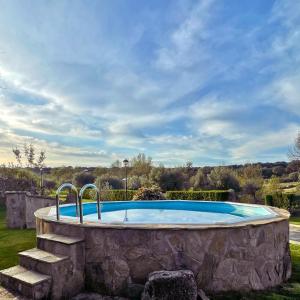 een groot stenen zwembad in een tuin bij Casa Rural El Lagar del Abuelo en los Arribes del Duero, Badilla, Zamora in Zamora