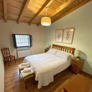 een slaapkamer met een groot bed en een stoel bij Casa Rural El Lagar del Abuelo en los Arribes del Duero, Badilla, Zamora in Zamora