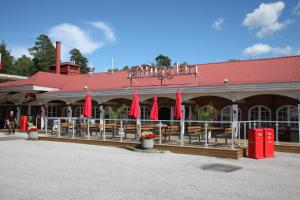 マリエスタードにあるRasta Mariestadの赤い傘とテーブルと椅子が備わるレストラン