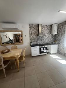 uma cozinha com uma mesa, cadeiras e um espelho em Apartamento loft, jardín y piscina privada em Romanyá de la Selva