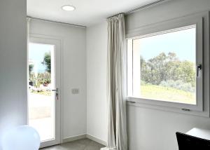 a window in a white room with a large window at Sole Matto Rooms in Olbia