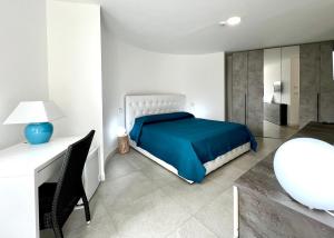 a bedroom with a bed and a desk with a chair at Sole Matto Rooms in Olbia
