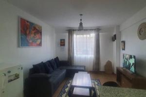 uma sala de estar com um sofá e uma mesa em VillaRoma's Urban Retreat A Stylish Warm Loft em Eldoret