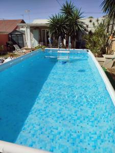 uma grande piscina com água azul em San Roque Countryside Annex em San Roque