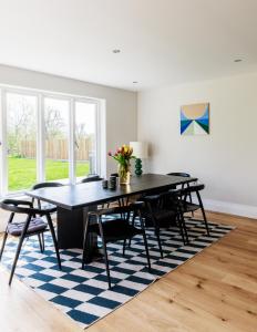 a dining room with a table and chairs on a rug at 4BD Luxurious Countryside Retreat Scenic Views in Worplesdon