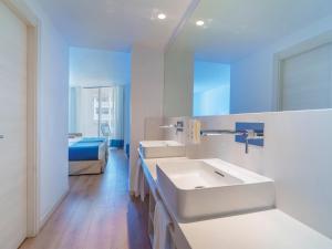 a white bathroom with two sinks and a bed at Spirit Hotel Benalmadena Beach in Benalmádena