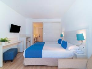 a hotel room with a large bed and a desk at Spirit Hotel Benalmadena Beach in Benalmádena