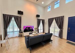 sala de estar con sofá y TV en A'famosa Bungalow Villa 859, en Kampong Alor Gajah