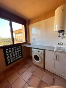 a kitchen with a washing machine and a sink at Apartamentos Turísticos Spiritmar in Almerimar