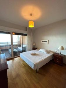 um quarto com uma grande cama branca e uma varanda em Apartamentos Turísticos Spiritmar em Almerimar