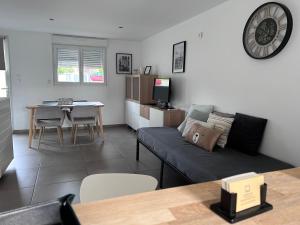 ein Wohnzimmer mit einem Sofa und einem Tisch in der Unterkunft La belle étoile in Roye