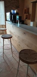 twee tafels en twee krukken voor een bar bij Agorà Mediterranea in Ceraso
