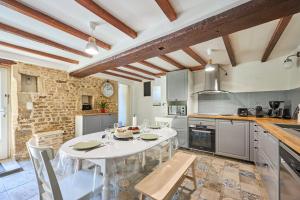 a kitchen with a white table and chairs at Augustine Beach - Maison à 700 m de la plage in Courseulles-sur-Mer