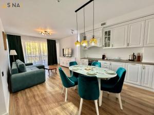 una cucina e un soggiorno con tavolo e sedie di SINAI APH Apartments a Sinaia